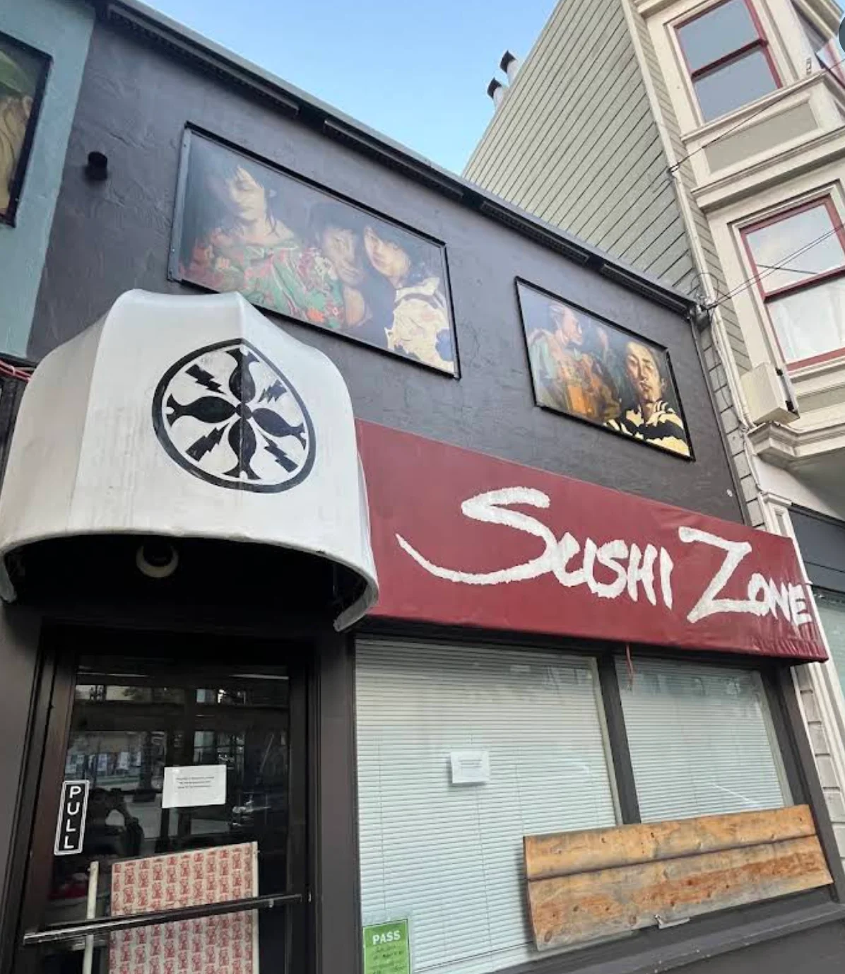 Exterior view of Sushi Zone restaurant with artistic signage and window decor
