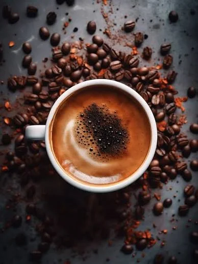 Rich espresso coffee topped with crema and surrounded by coffee beans