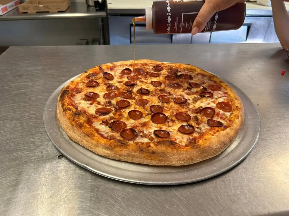 Pepperoni pizza on a metal tray in a pizzeria