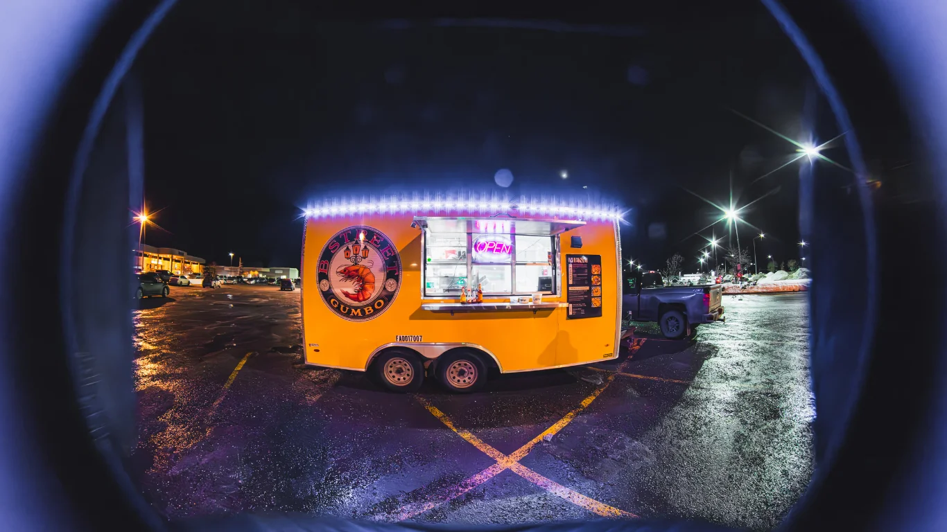 Brightly lit food truck serving Cajun gumbo at night