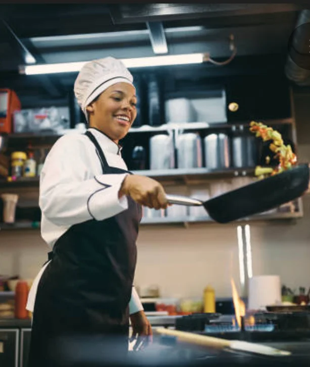 Chef skillfully tossing vegetables in a pan in a modern kitchen