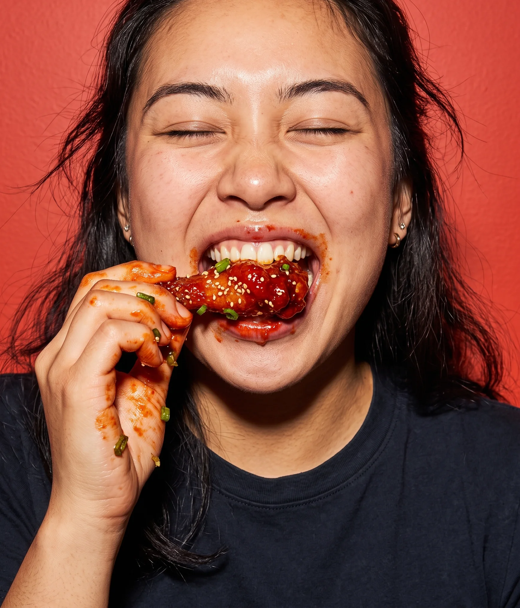 Enjoying Korean fried chicken with a joyful expression