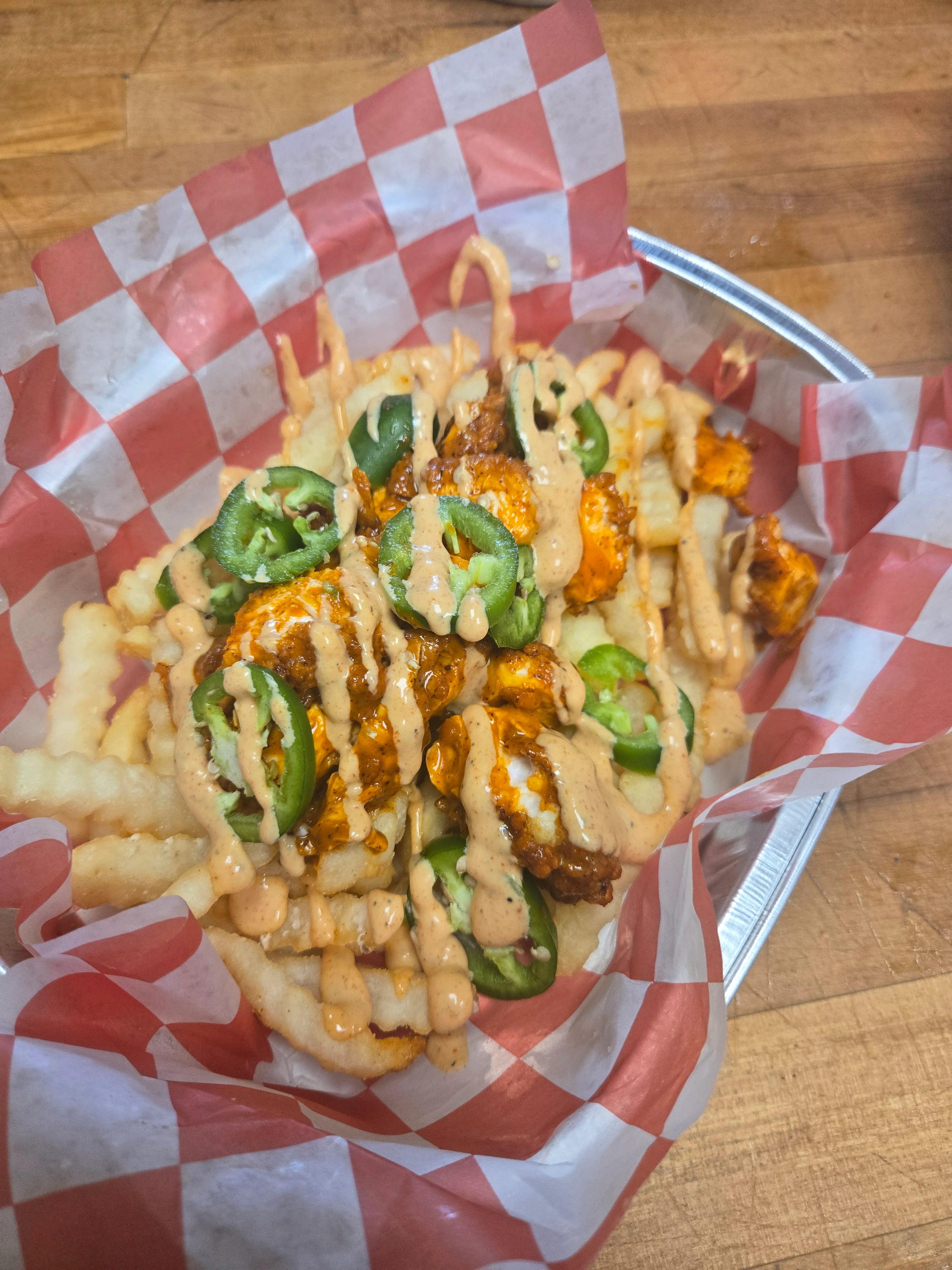 Loaded fries topped with spicy chicken and jalapeños