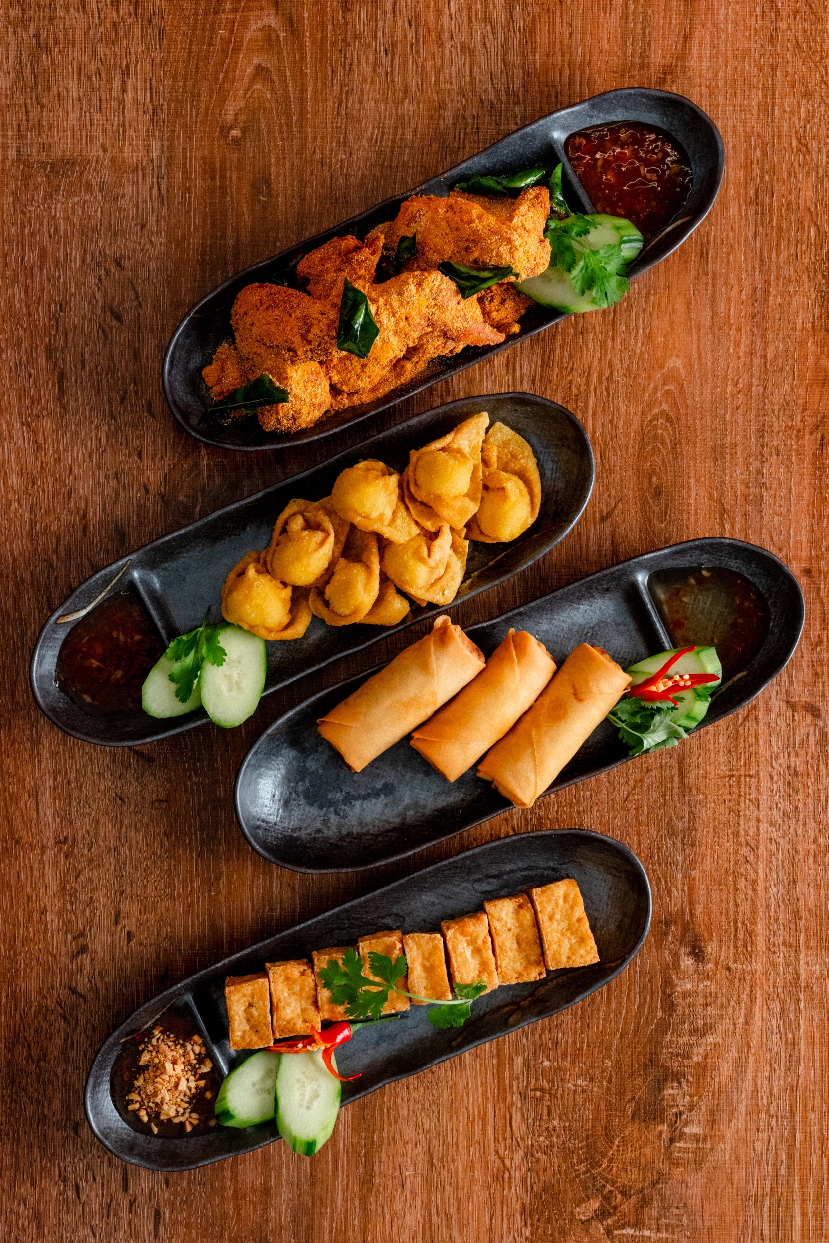 Assorted Asian appetizers including spring rolls and tofu