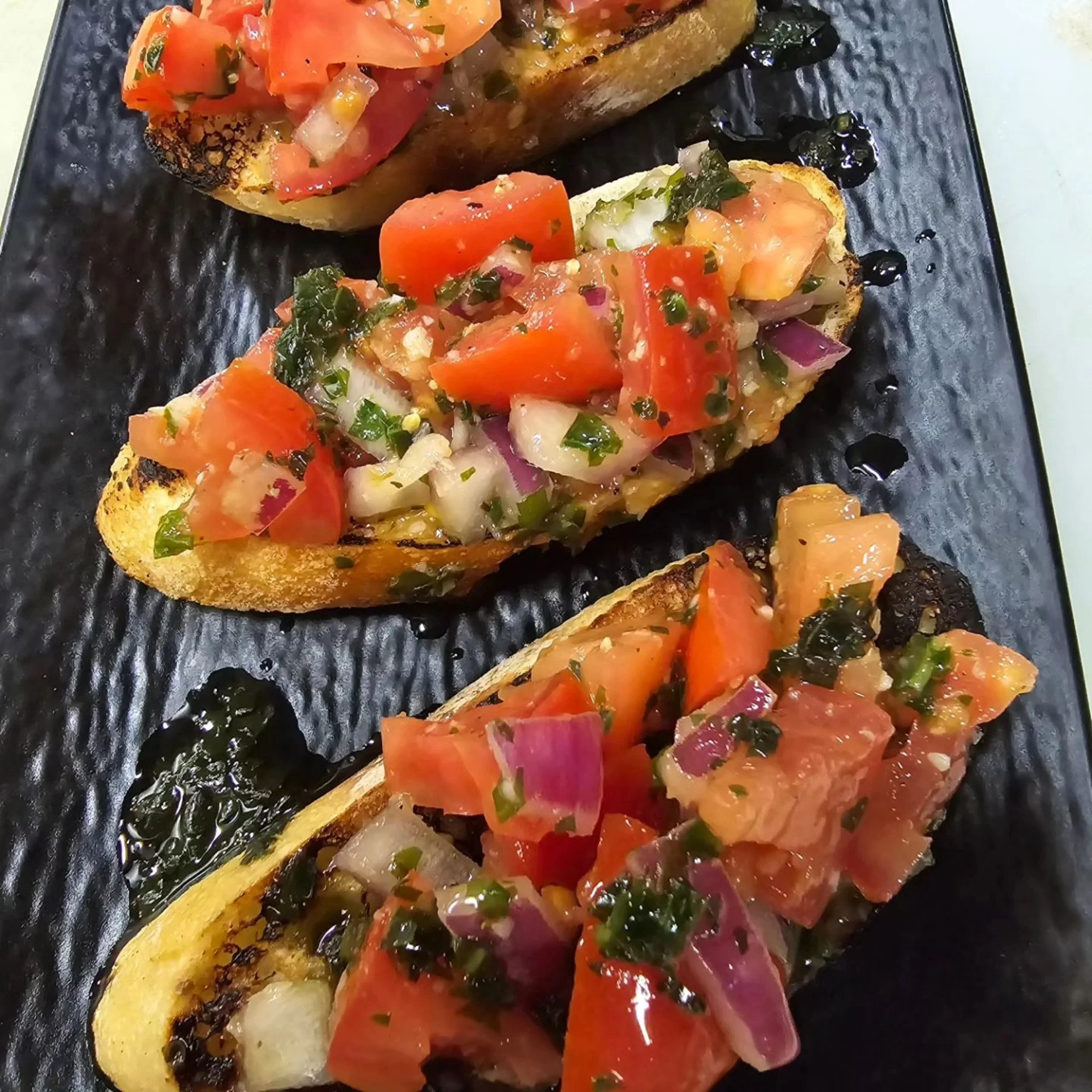 Italian bruschetta topped with fresh tomatoes and herbs