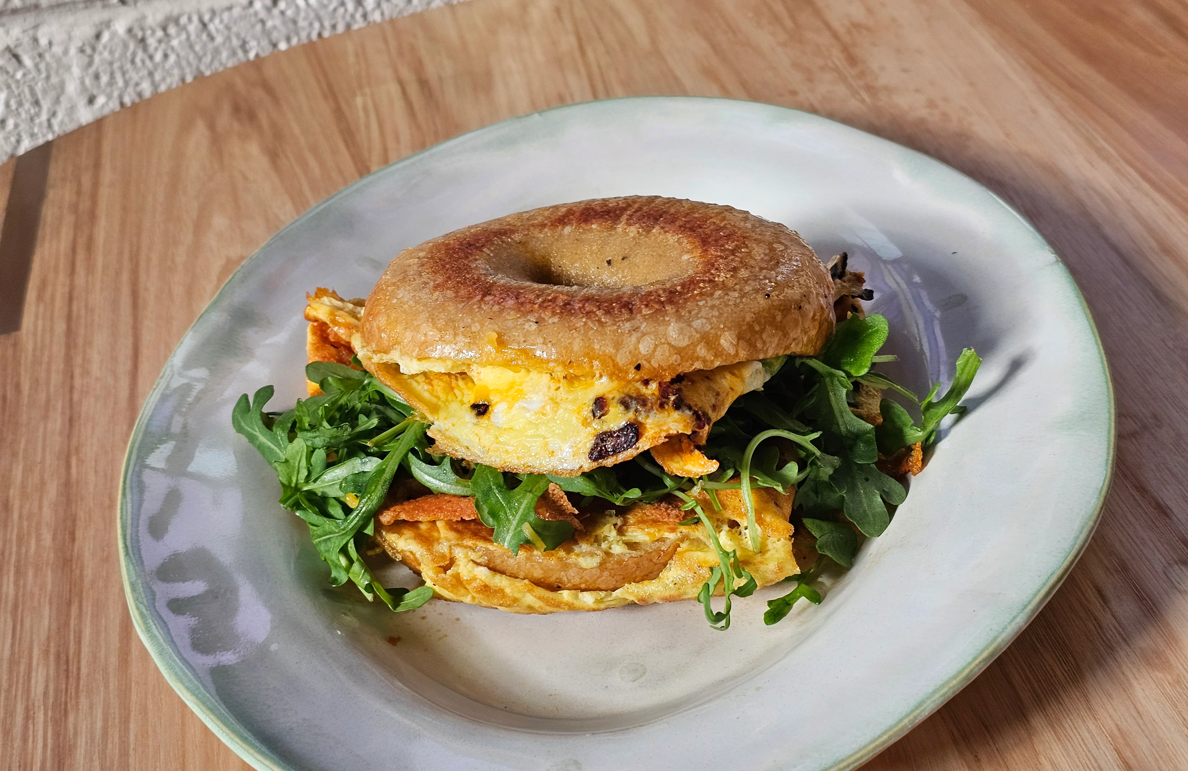 Bagel sandwich with scrambled eggs and arugula