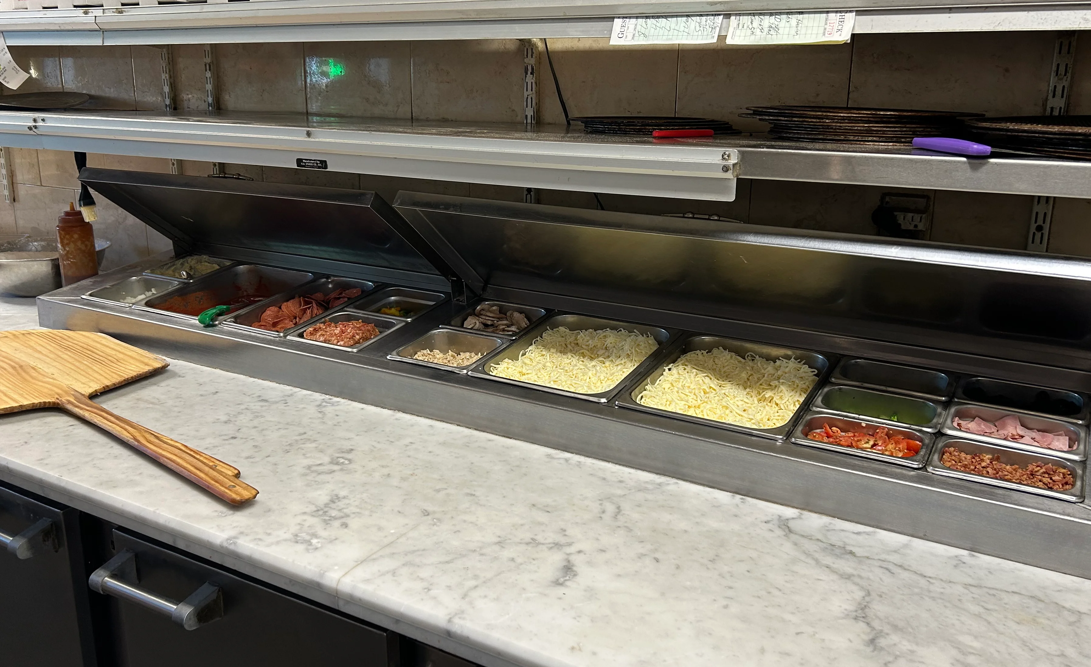 Pizza preparation area with fresh ingredients and pizza boxes
