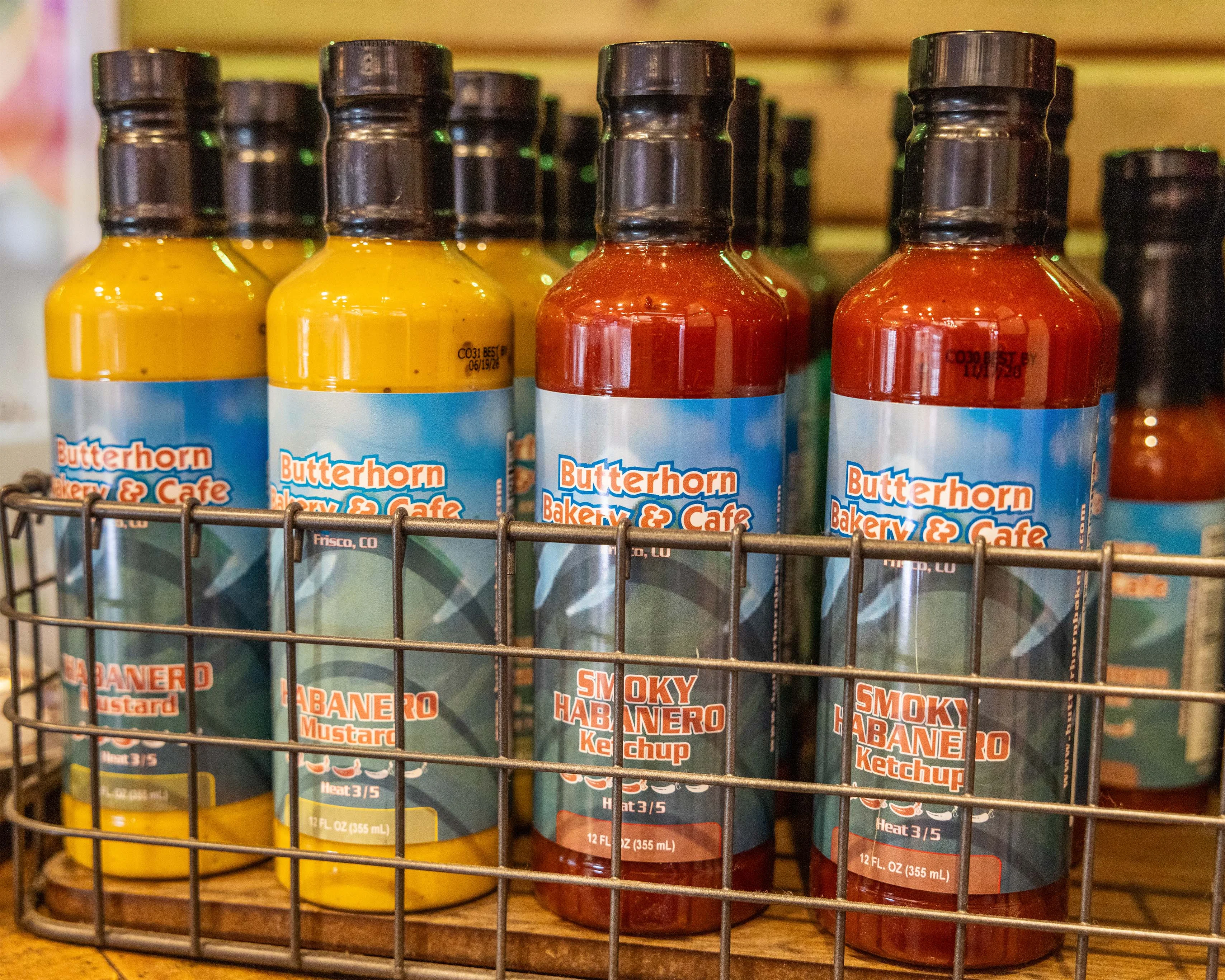 Colorful hot sauce bottles displayed in a restaurant condiment rack