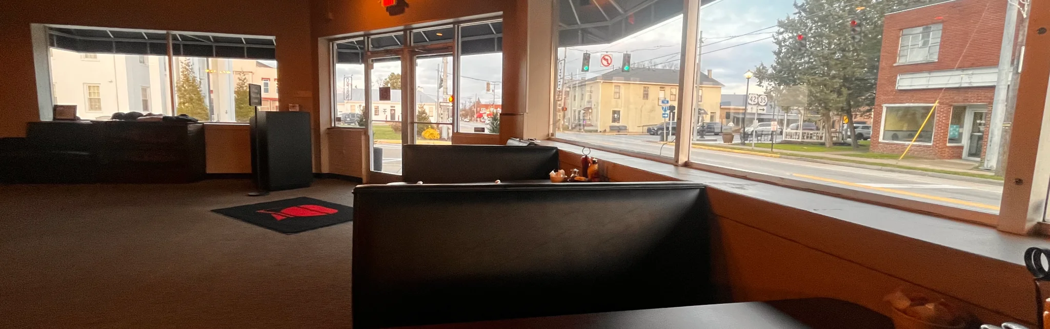 Cozy restaurant interior with large windows and booth seating