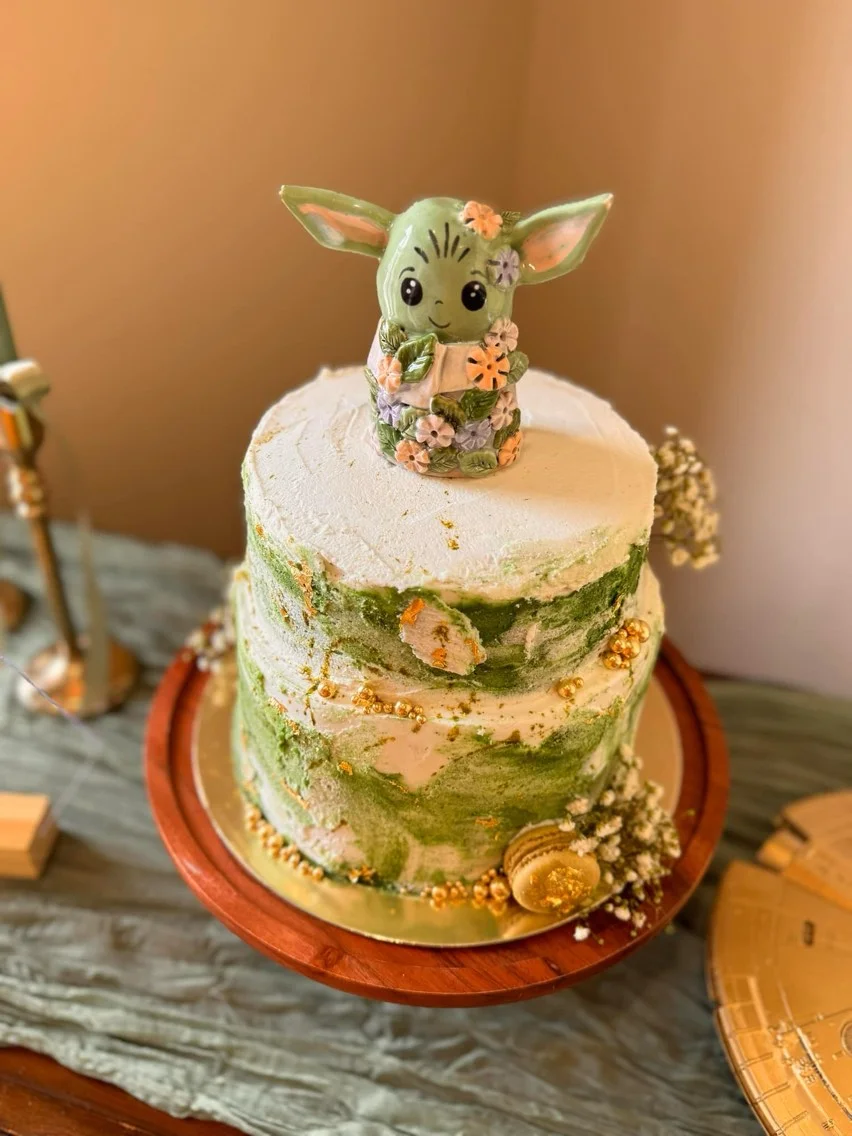 Whimsical cake topped with a floral figurine in pastel colors