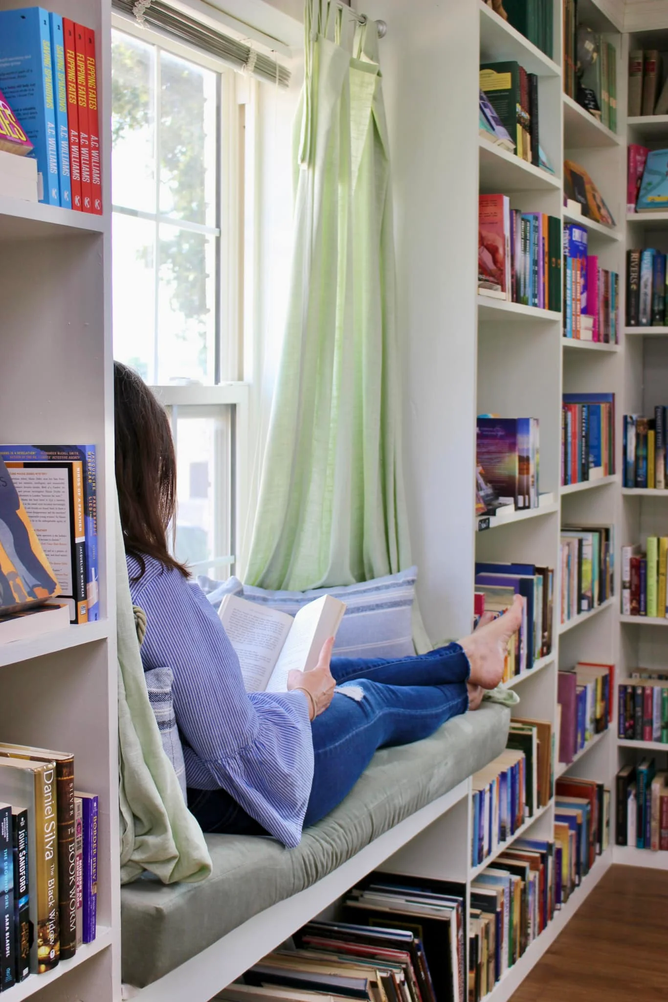 Cozy restaurant window seat with books and a warm ambiance.