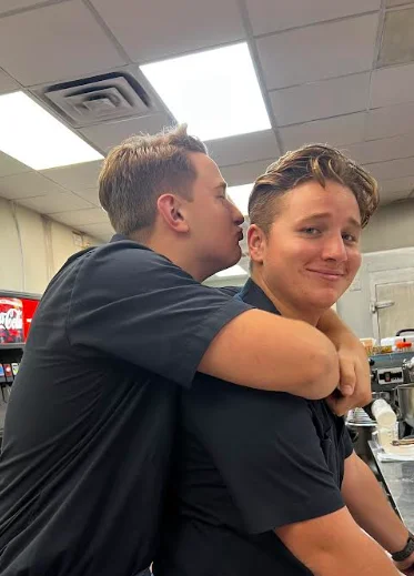 Two chefs sharing a lighthearted moment in a restaurant kitchen