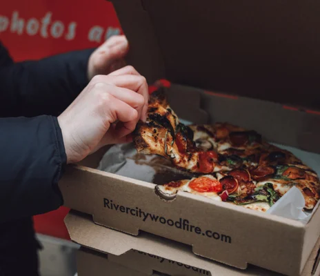 River City Wood Fire Pizza in a box being eaten by