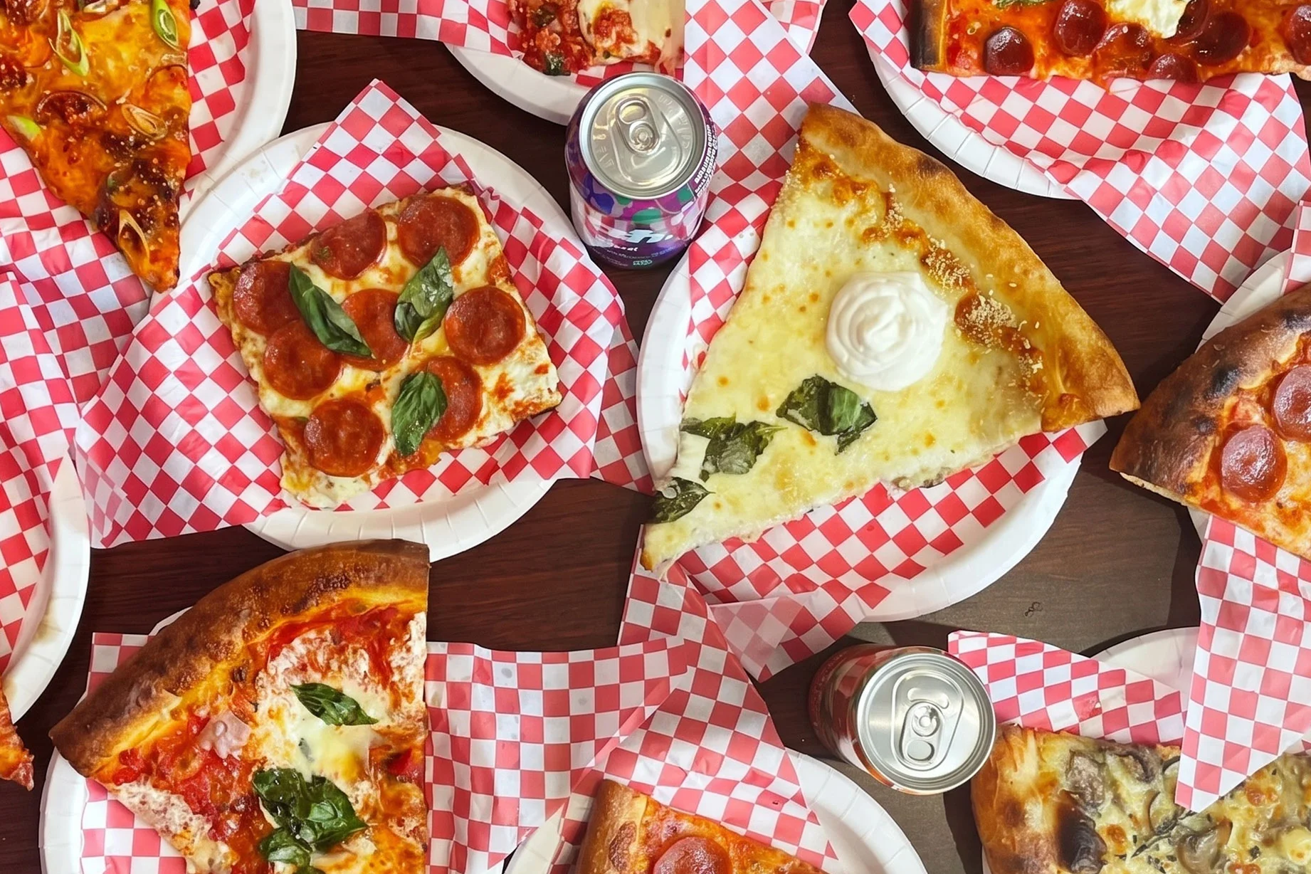 Variety of pizzas on paper plates with red checkered design