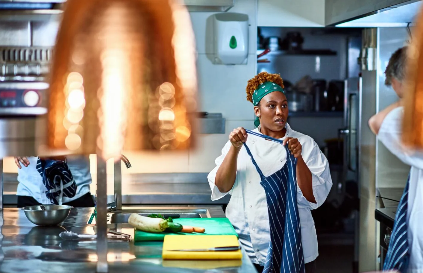 Cook reading orders in kitchen at Tolex African Grill
