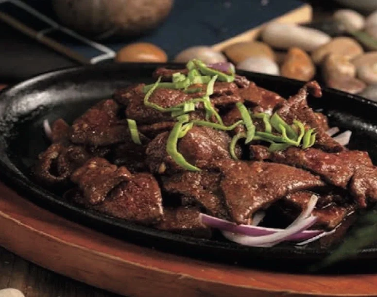 Sizzling Filipino beef tapa served on a hot plate