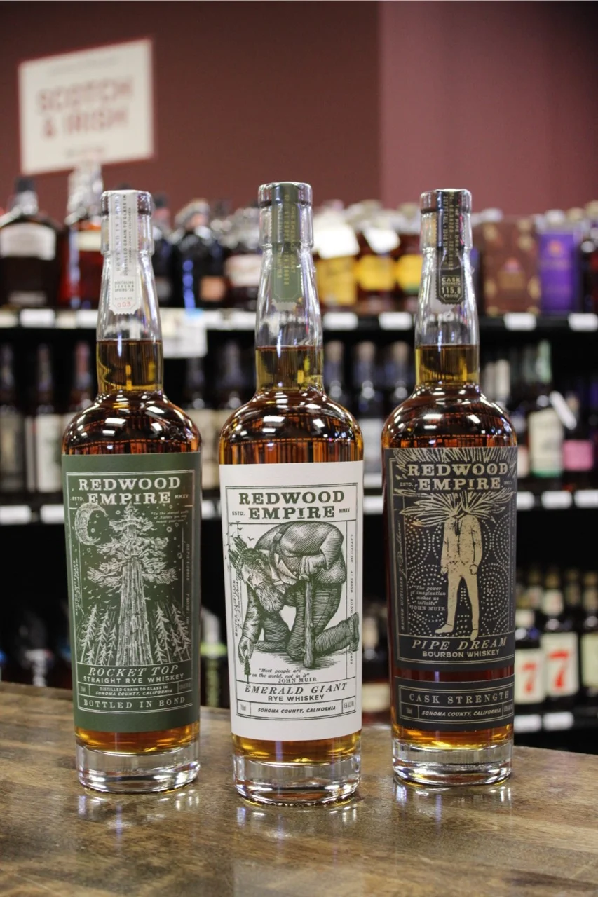 Selection of Redwood Empire whiskey bottles on a wooden counter