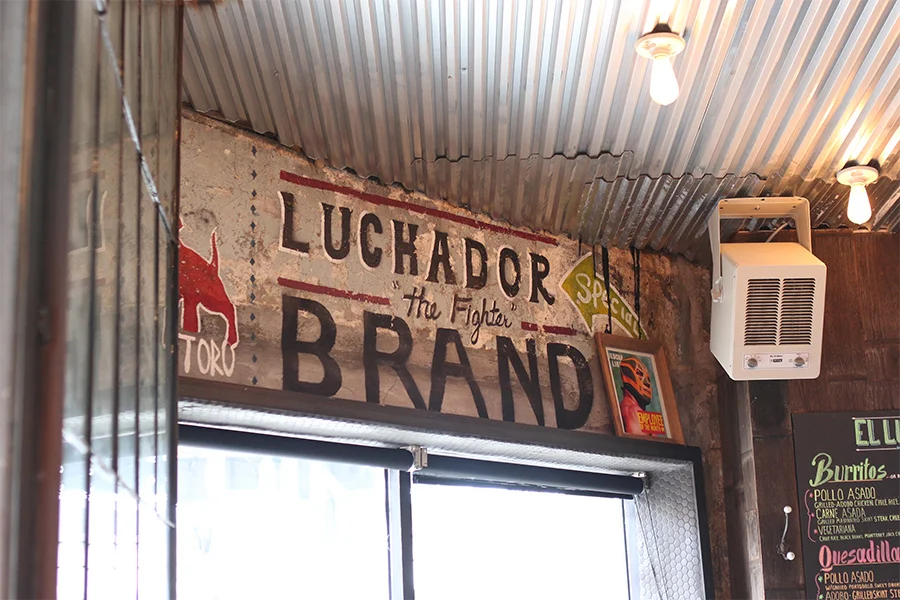 Rustic restaurant interior featuring Luchador-themed decor and warm lighting