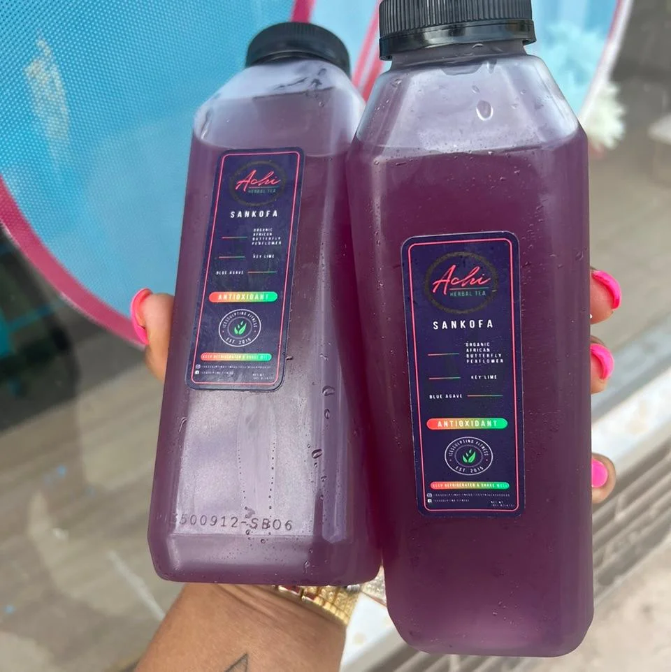 Two bottles of herbal tea, dark purple in color, positioned together showcasing their unique labels. The design emphasizes a health-focused theme.
