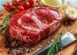 A beautifully cooked bison ribeye steak on a plate.
