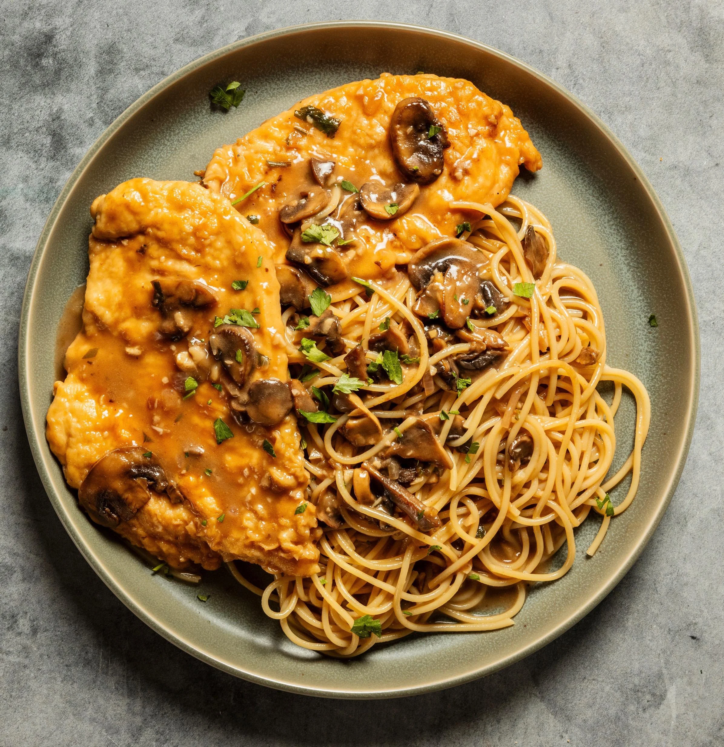 Chicken marsala with sautéed mushrooms served over spaghetti in a rich marsala wine sauce at Tommy’s Pizza in South Richmond Hill, Queens NY
