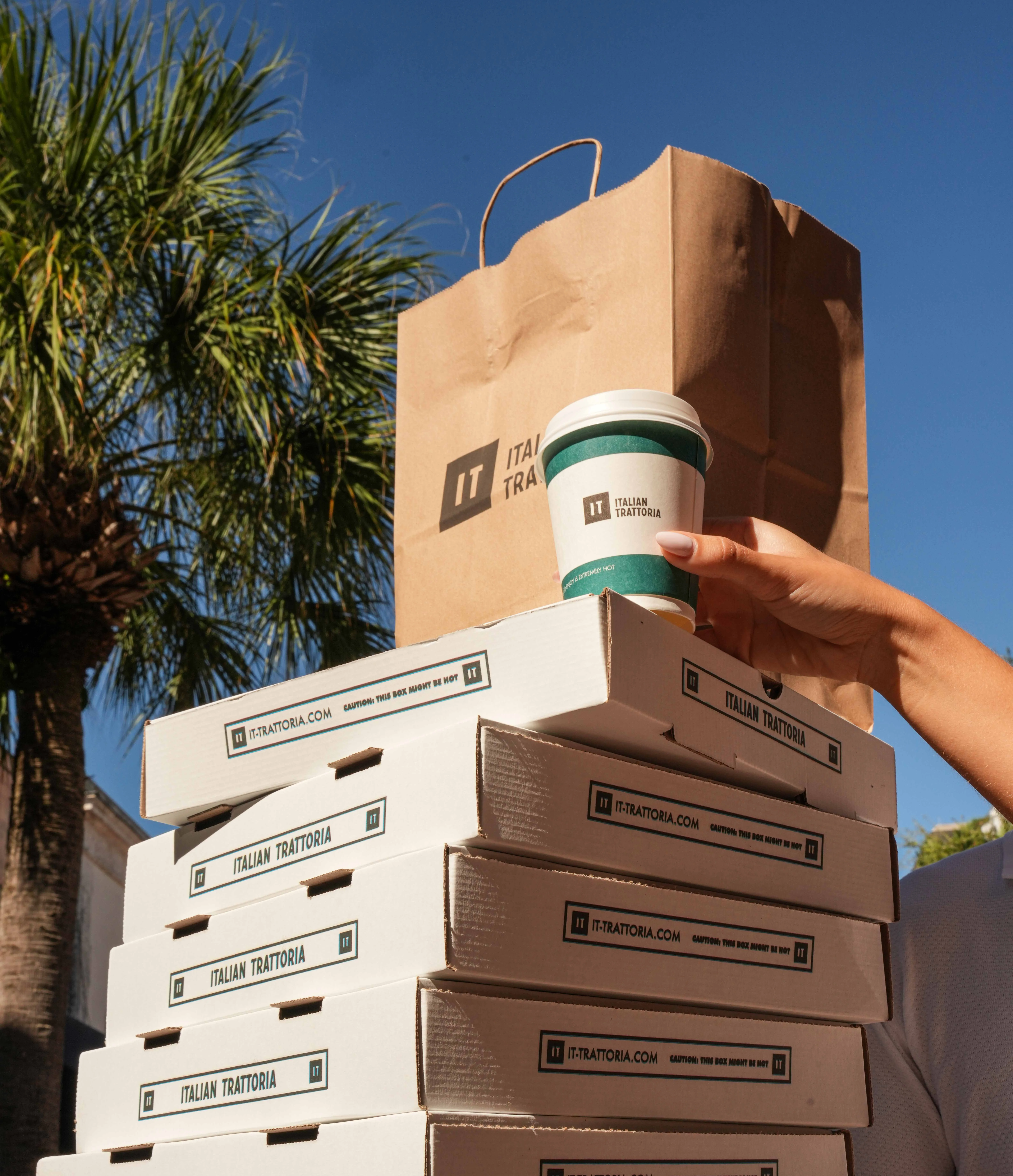 Stack of pizza boxes from an Italian trattoria with coffee cup