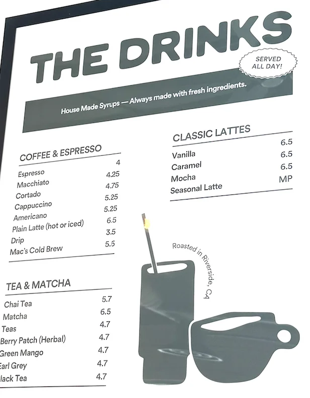 Menu board displaying drinks with prices at a café.