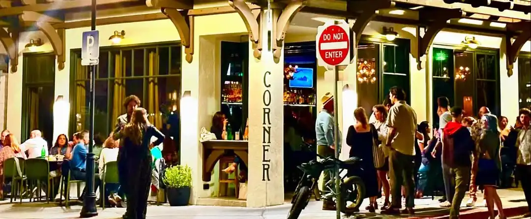 in front of corner bar, lots of people around