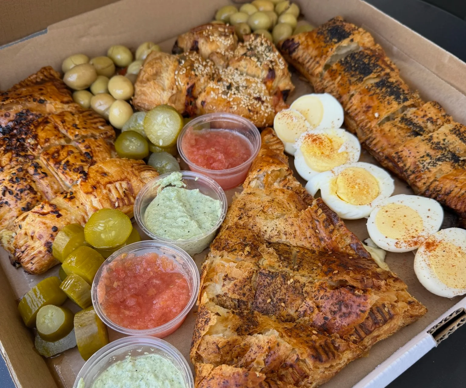 Assorted Mediterranean pastries and dips in a takeout box
