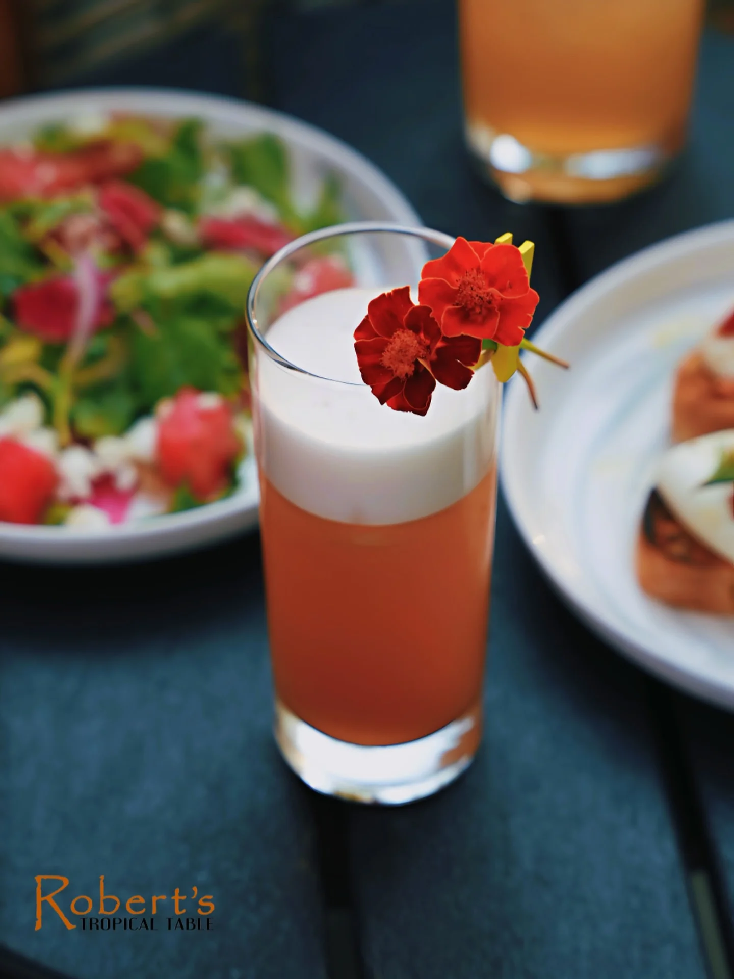 Tropical cocktail garnished with edible flowers