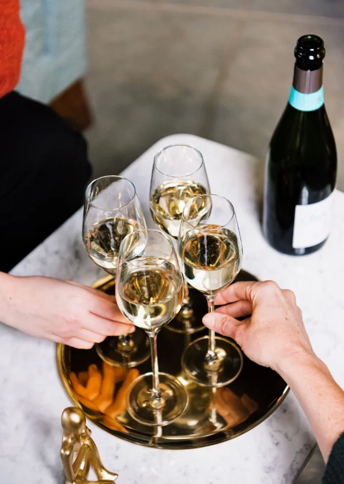 Cheers with sparkling wine in elegant glasses on a gold tray