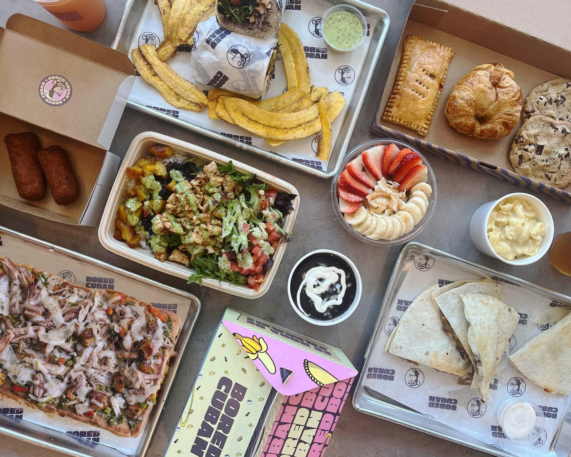 Cuban food spread with plantains, empanadas, croquettes, sandwiches, and tropical fruit