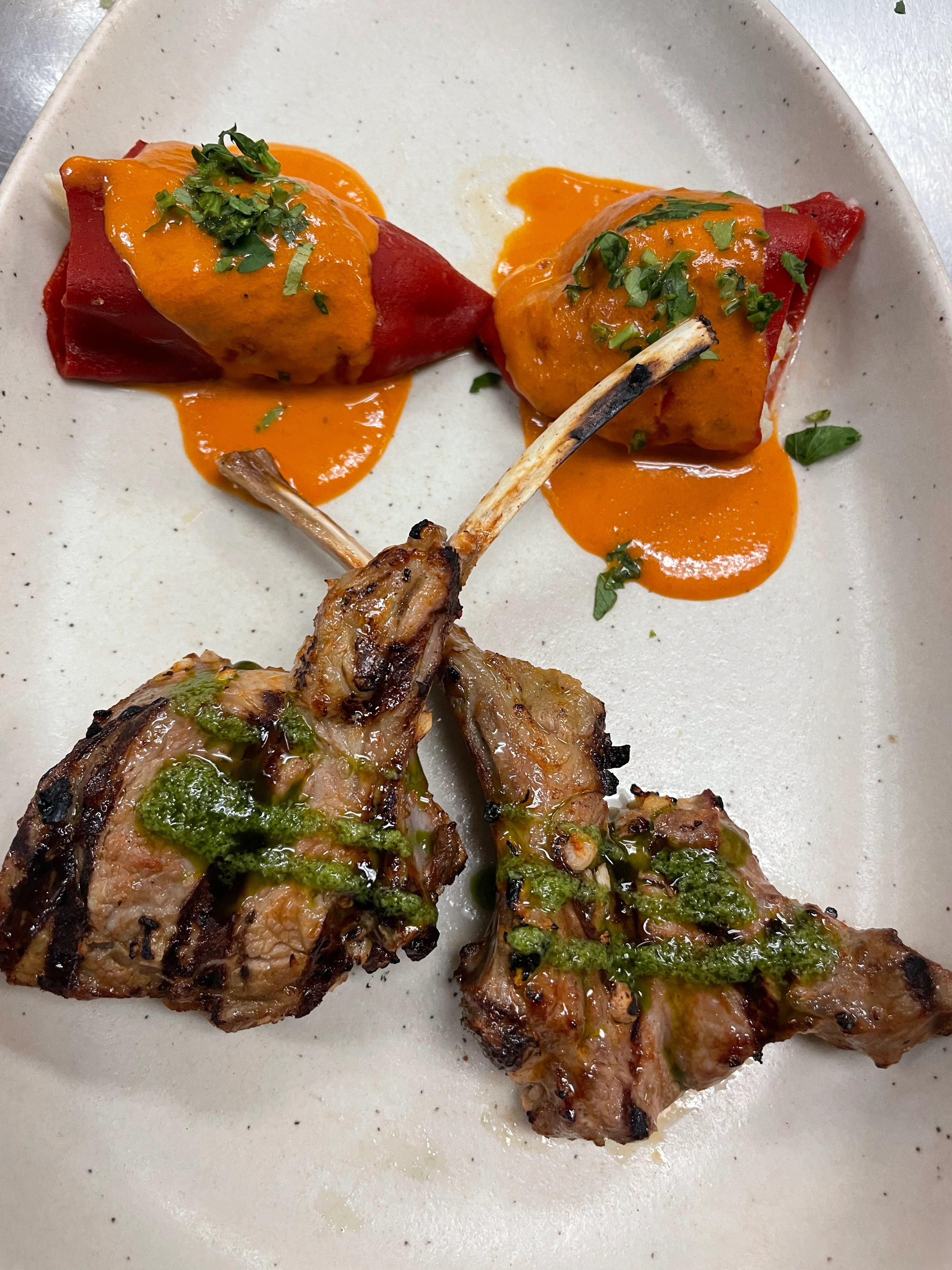 Grilled lamb chops with red pepper sauce and herbs