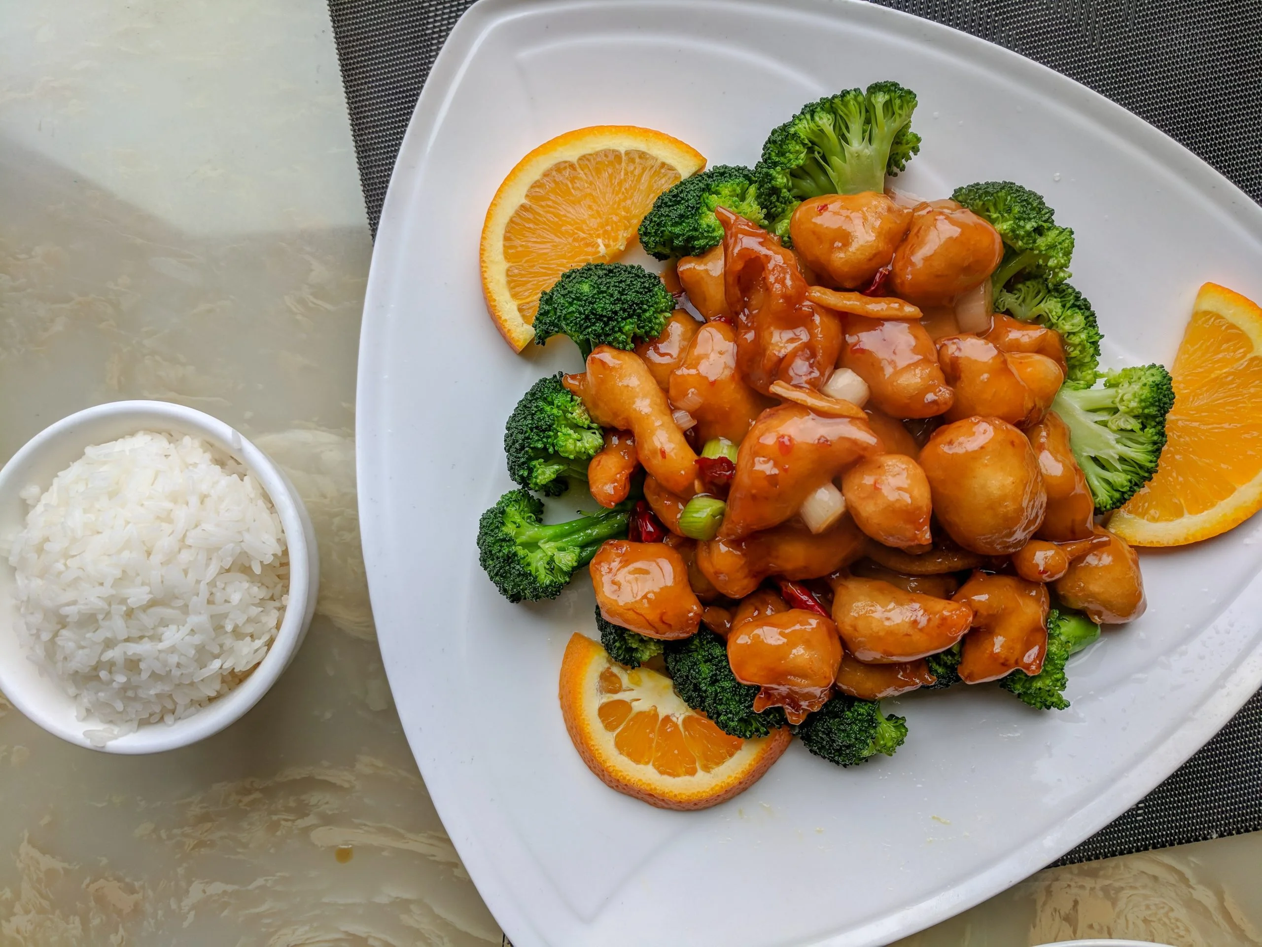 Orange chicken served with broccoli and rice