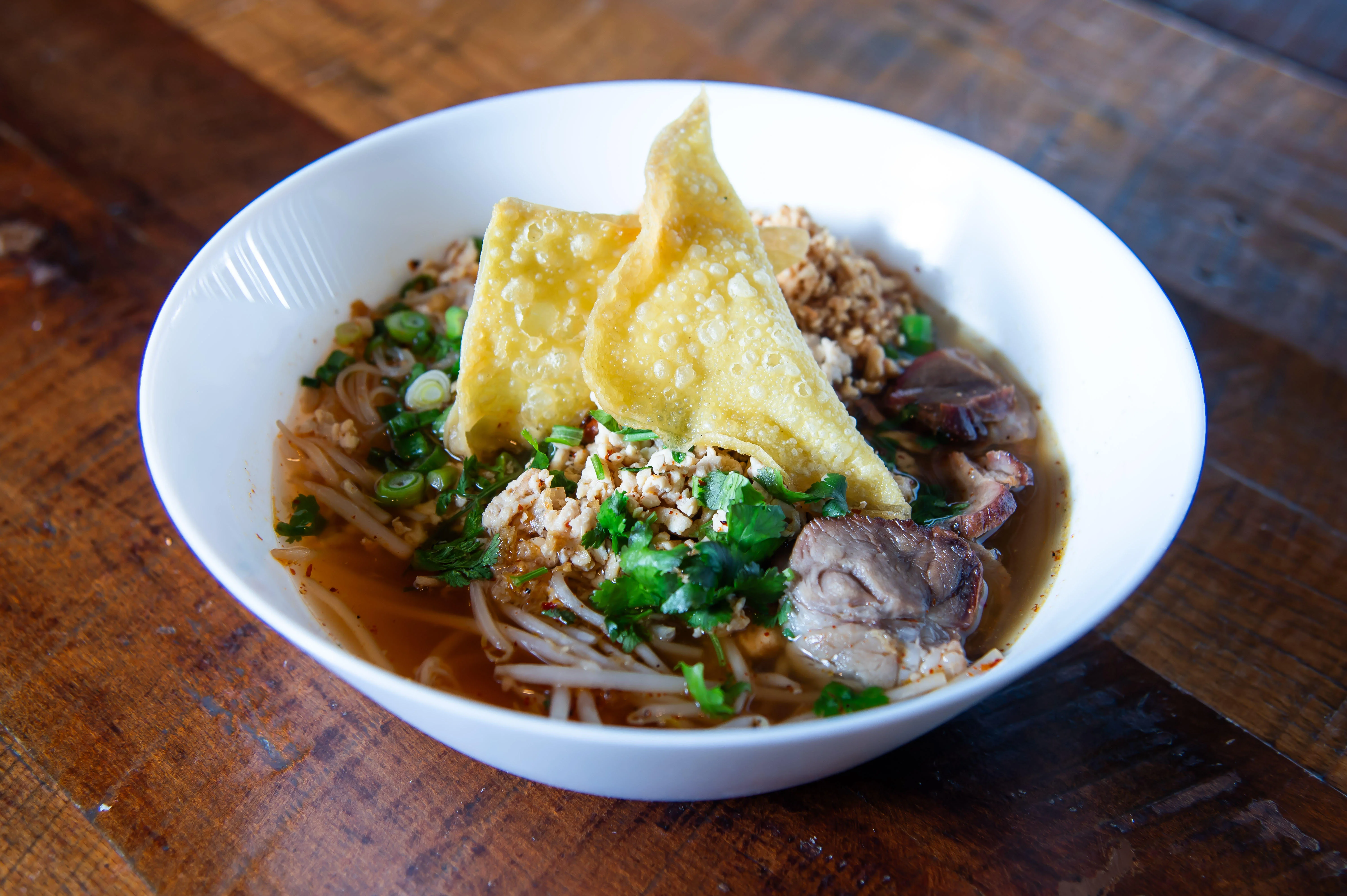 Bowl of Thai boat noodles with crispy wontons
