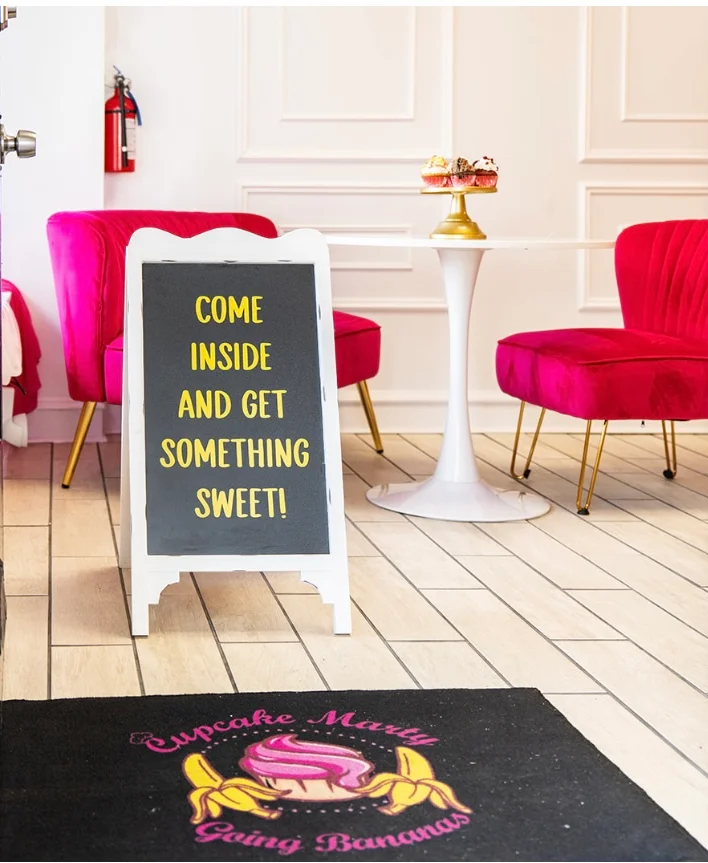 Inviting dessert shop entrance with pink seating and a sweet sign