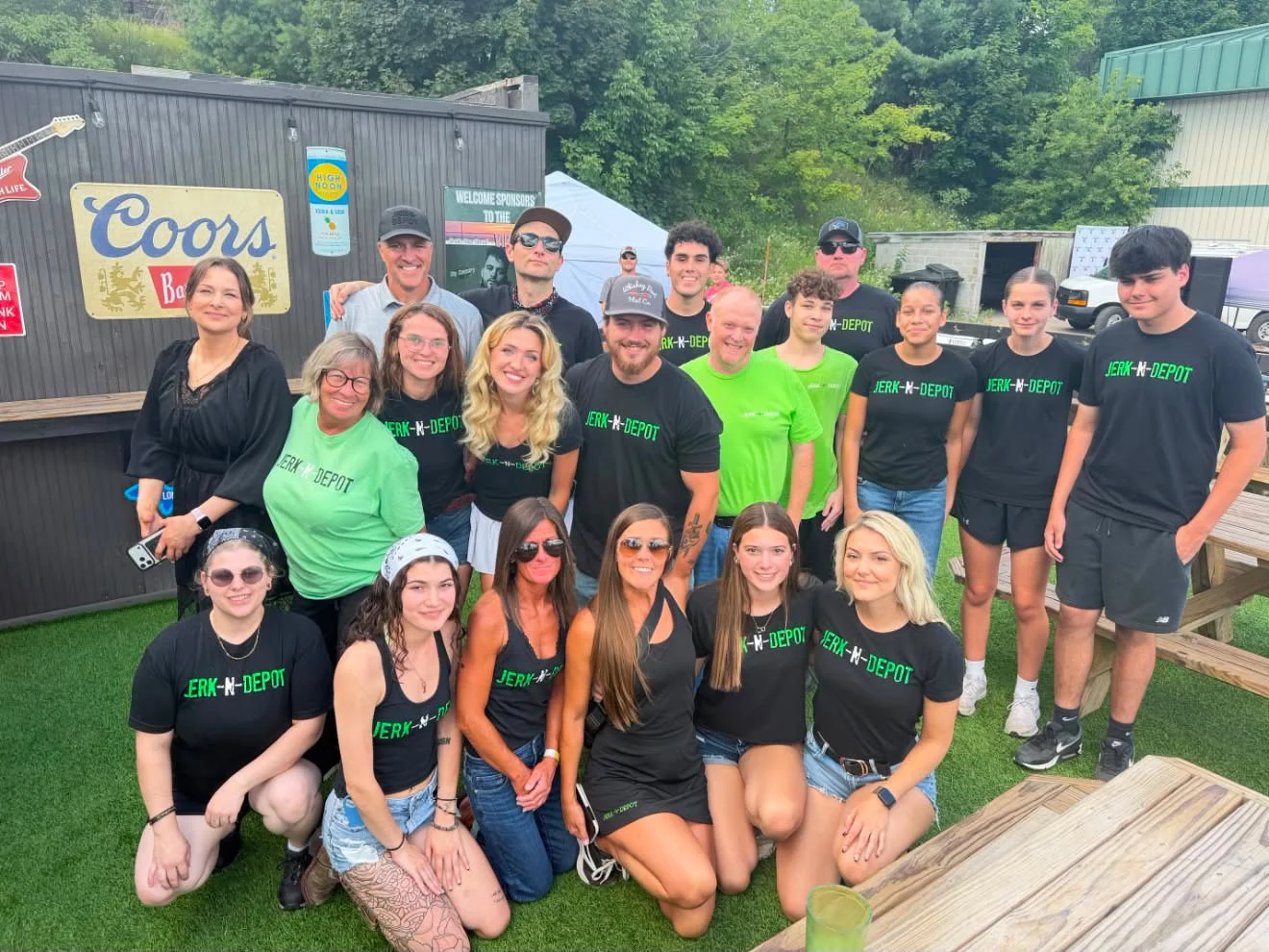 Group photo of restaurant staff in branded shirts at an outdoor event