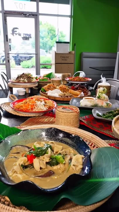 A vibrant indoor dining setting with a variety of dishes displayed, showcasing a colorful assortment of food, including salads and fried items.