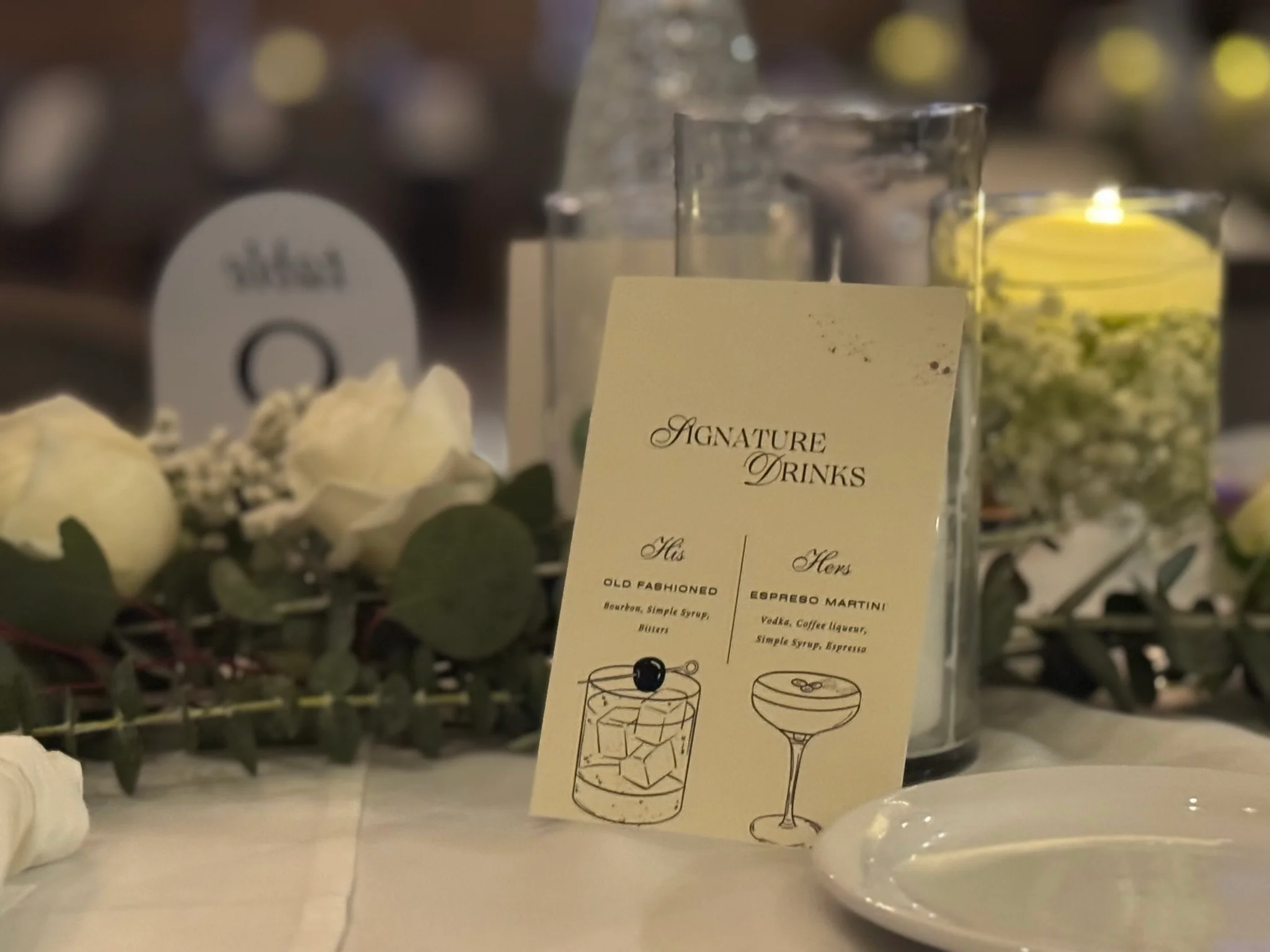 Elegant table setting with signature drink menu and floral decor