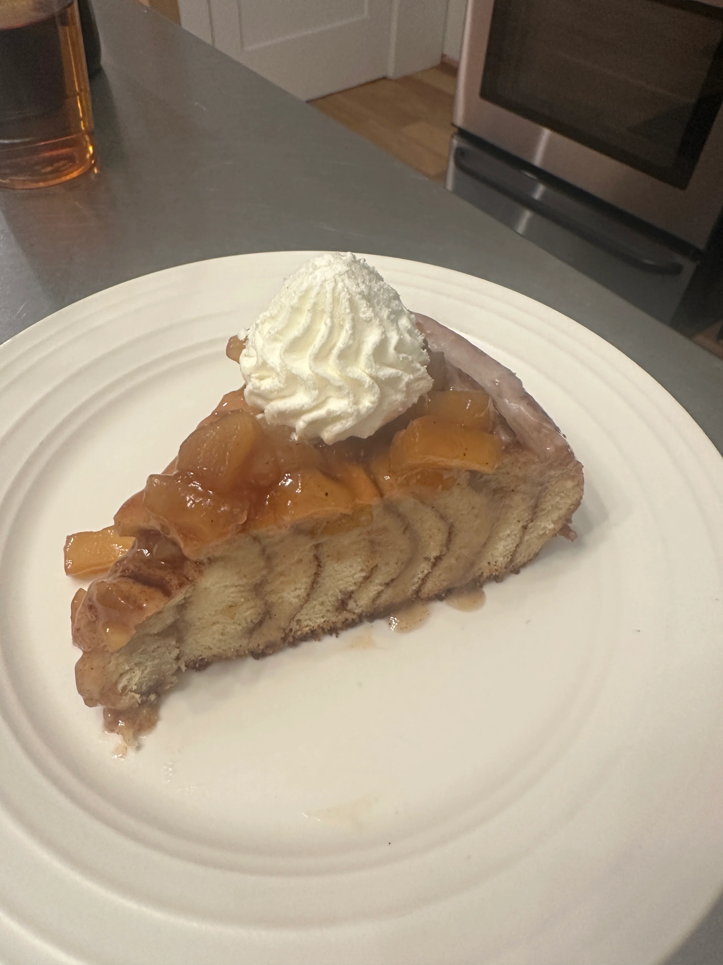 Delicious peach cobbler slice topped with whipped cream