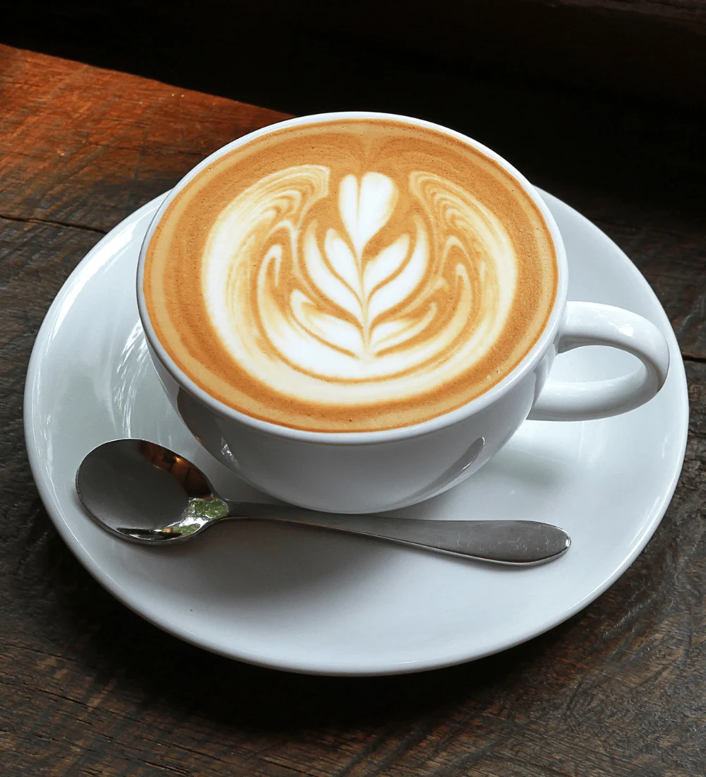 Artisan latte with intricate foam art in a white cup