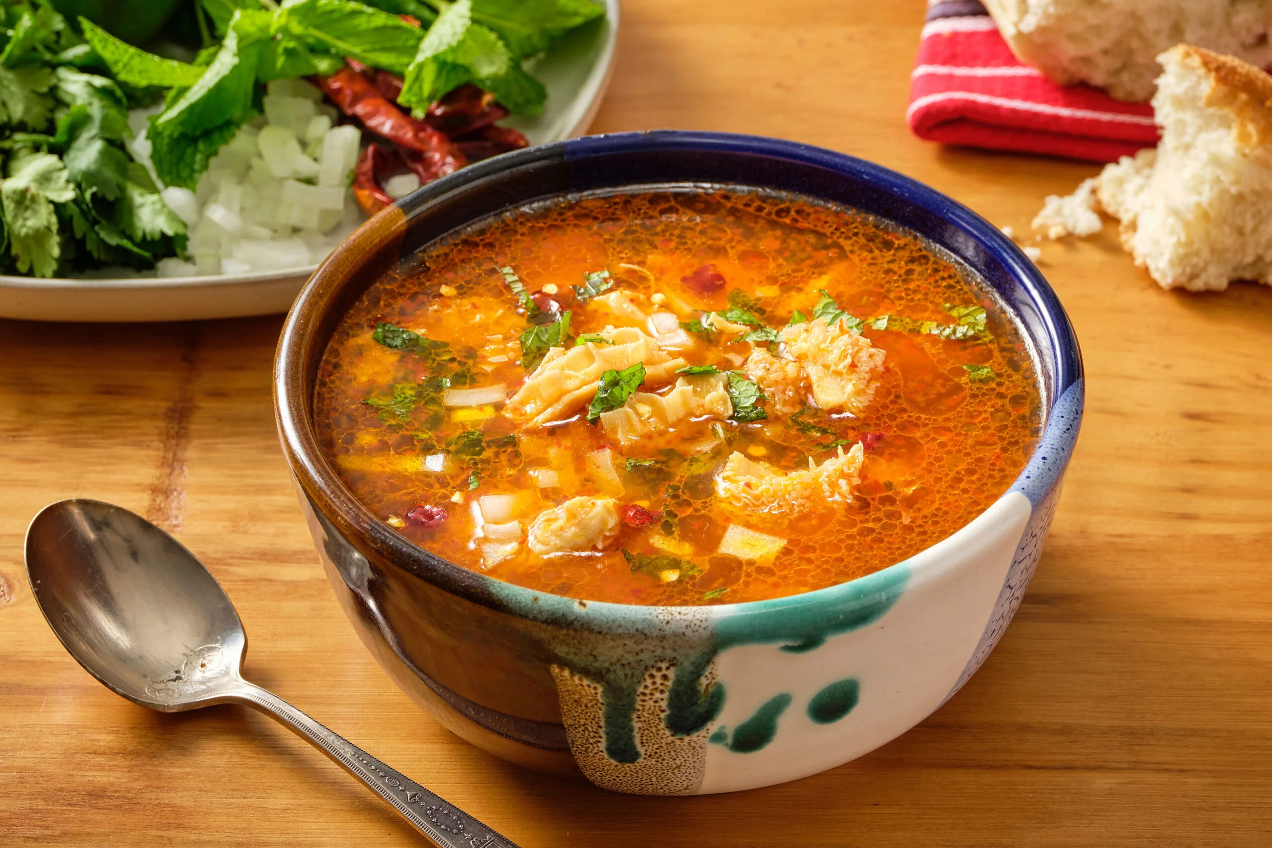 Bowl of spicy Mexican pozole with fresh herbs