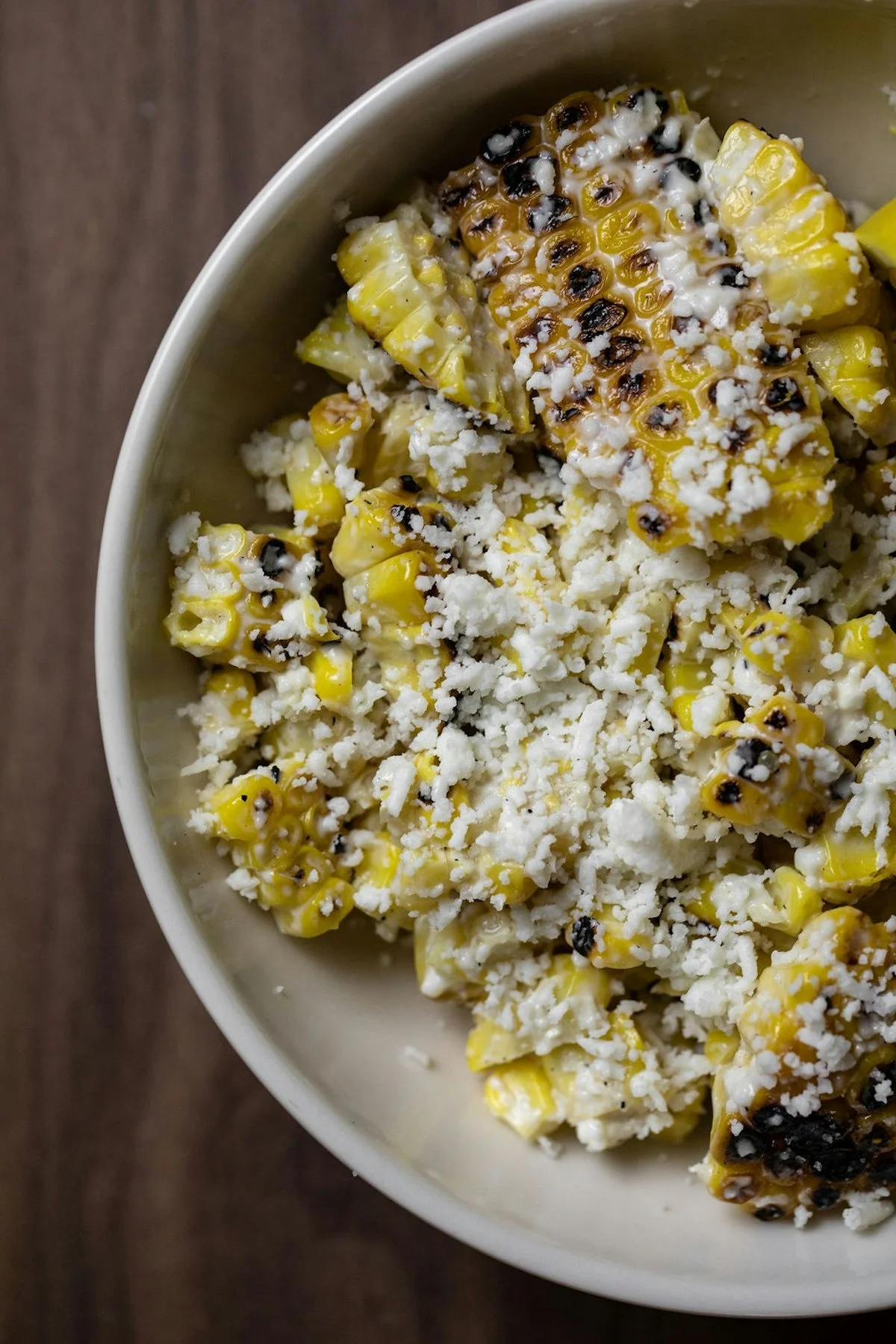 Mexican elote with cheese and spices in a bowl