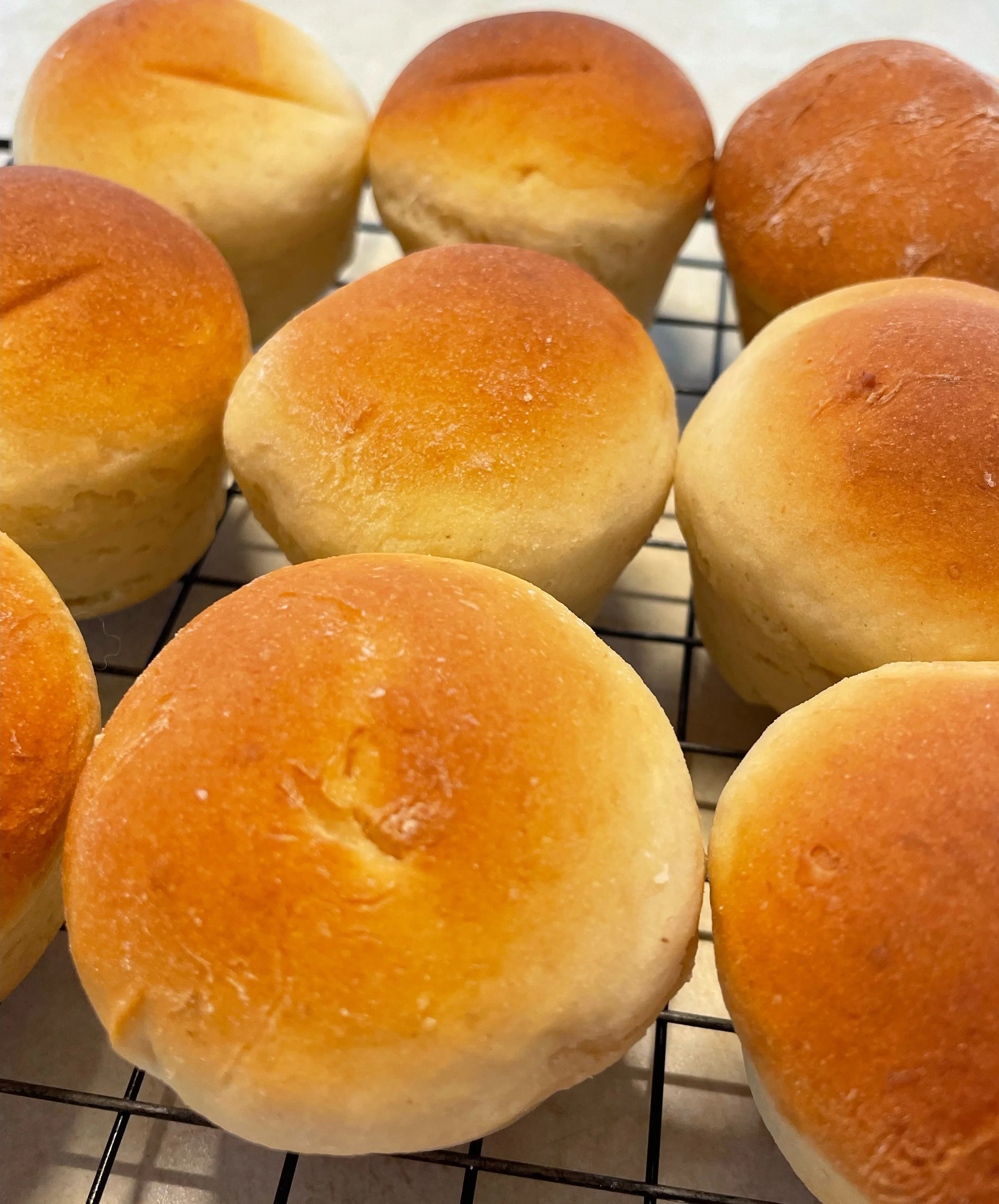Freshly baked dinner rolls cooling on a wire rack
