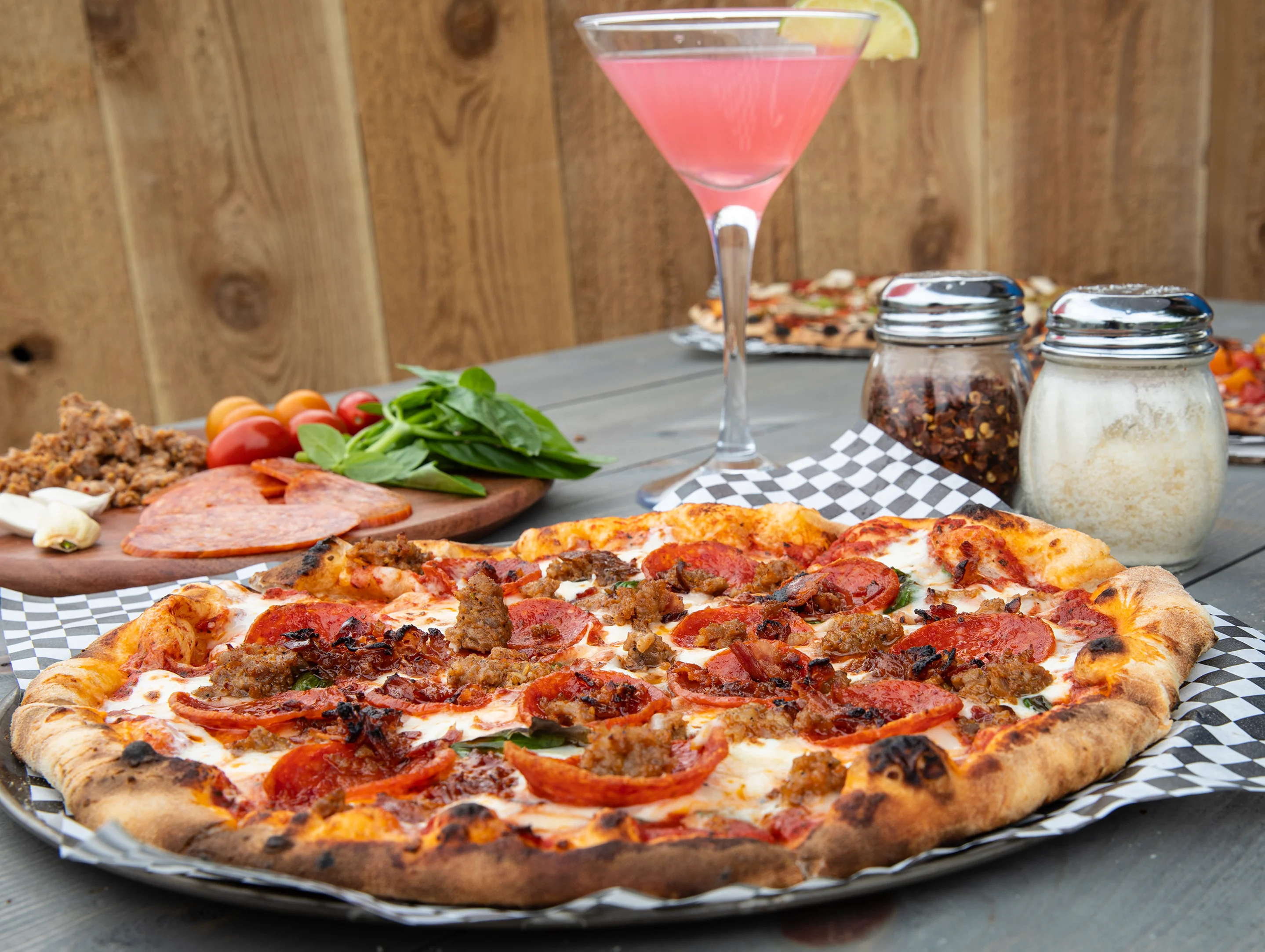 A pizza with a side of a cocktail