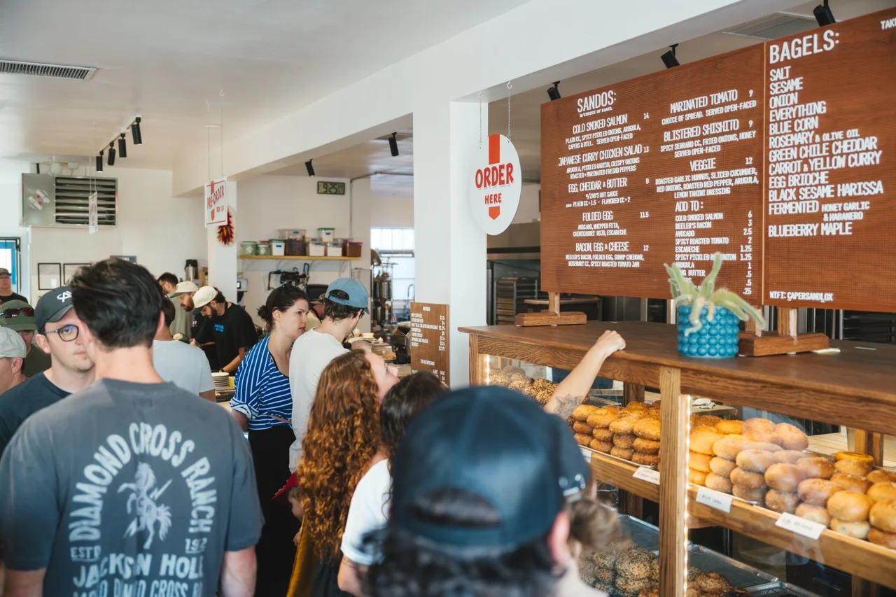 Busy café interior with a menu of bagels and sandwiches