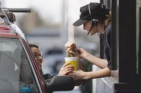 Customer receiving food at a drive-thru window