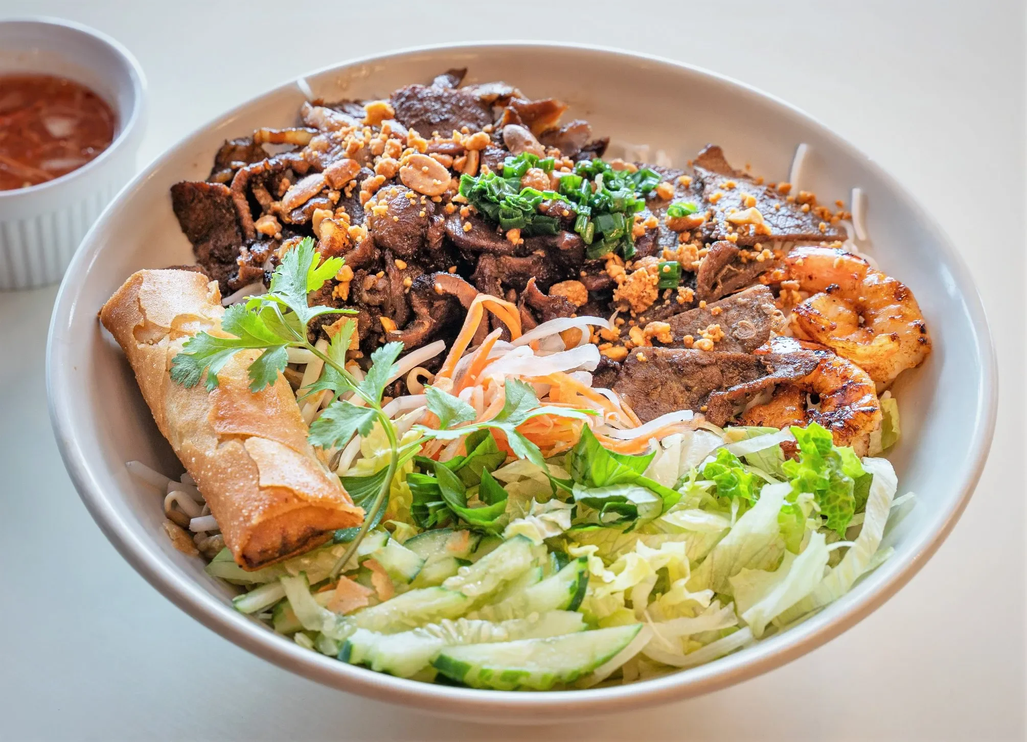 Vietnamese bun thit nuong with grilled meats and spring rolls