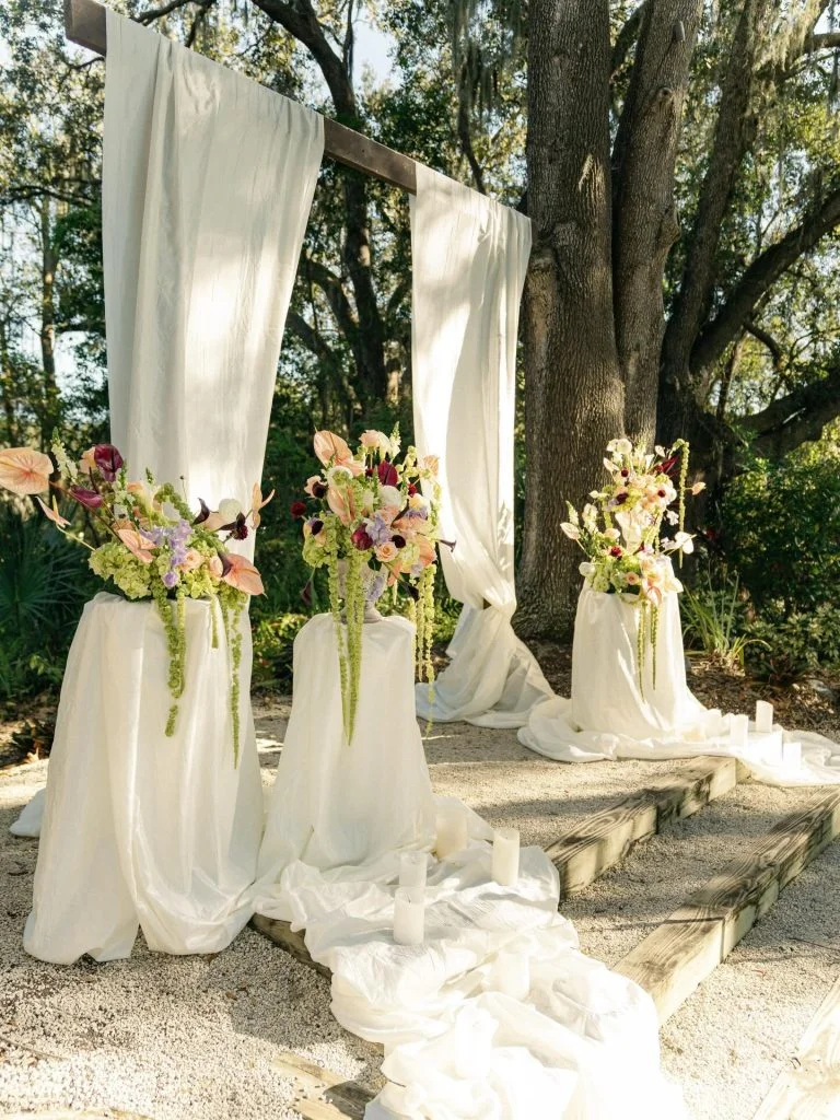 Elegant wedding altar with floral arrangements and draped fabric