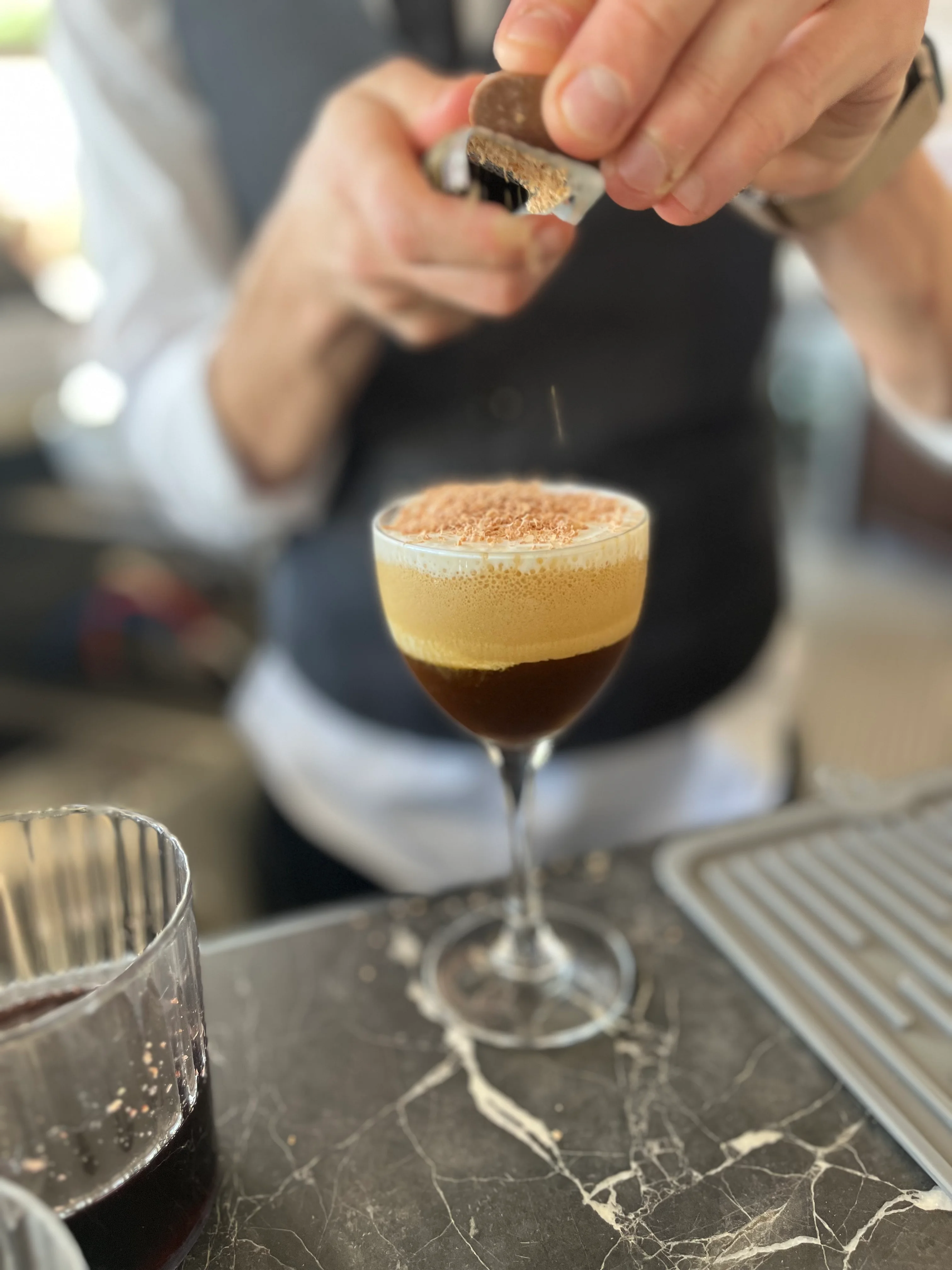 Bartender preparing a coffee cocktail with chocolate garnish